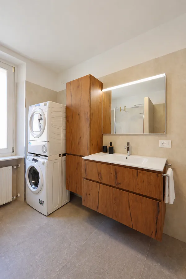 Lavatrice e asciugatrice accanto al lavabo nel bagno di Alkecè Collection
